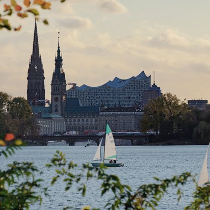 Blick auf die Hamburger Skyline mit der Elbphilharmonie und Segelbooten auf der Alster