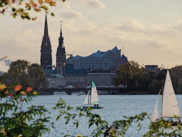 Blick auf die Hamburger Skyline mit der Elbphilharmonie und Segelbooten auf der Alster