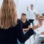 Person steht im Vordergrund und leitet ein Seminar