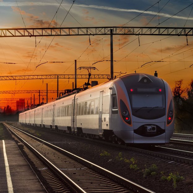 Moderner Zug bei Sonnenuntergang auf einer Bahnstrecke