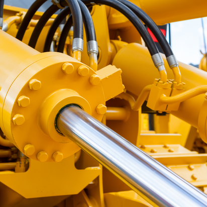 Ein Ausschnitt einer gelben hydraulischen Maschine