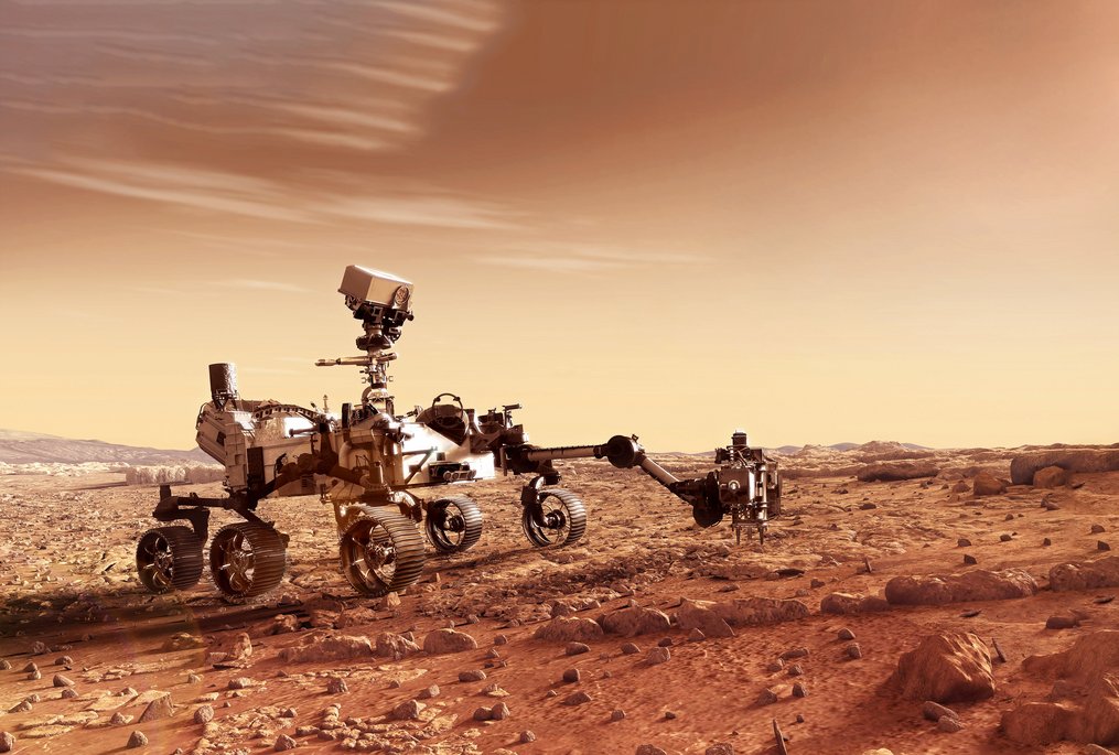 Ein sechsrädriger Mars-Rover mit wissenschaftlichen Instrumenten und Kameras steht auf der rötlichen Marsoberfläche. Die karge Landschaft zeigt rostfarbenes Gestein unter einem sandfarbenen Himmel mit charakteristischen Mars-Lichtverhältnissen.