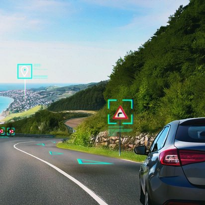 Auto auf Küstenstraße mit digitaler Verkehrszeichenerkennung