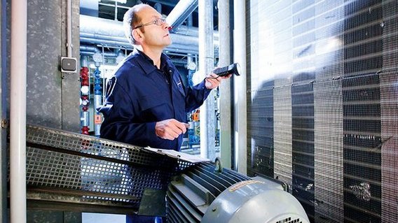 TÜV NORD-Techniker prüft industrielle Klimaanlage