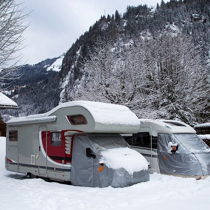 Wohnmobile im Schnee: Wintercamping in den Bergen Wohnmobile im Schnee in einer winterlichen Berglandschaft