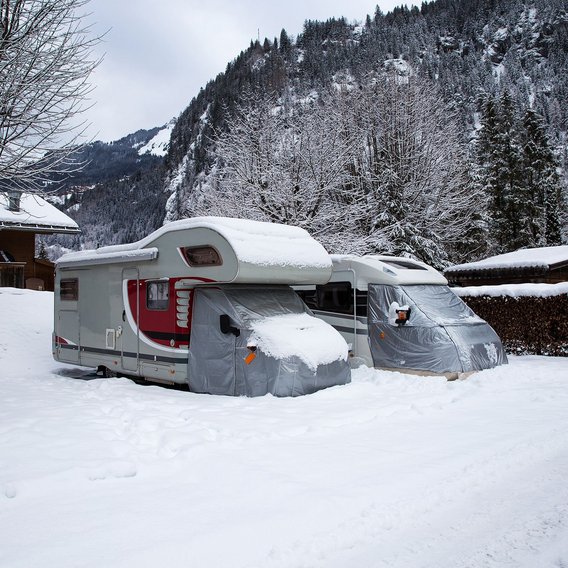 Wohnmobile im Schnee in einer winterlichen Berglandschaft