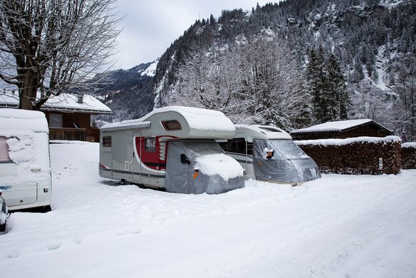 Wohnmobile im Schnee in einer winterlichen Berglandschaft
