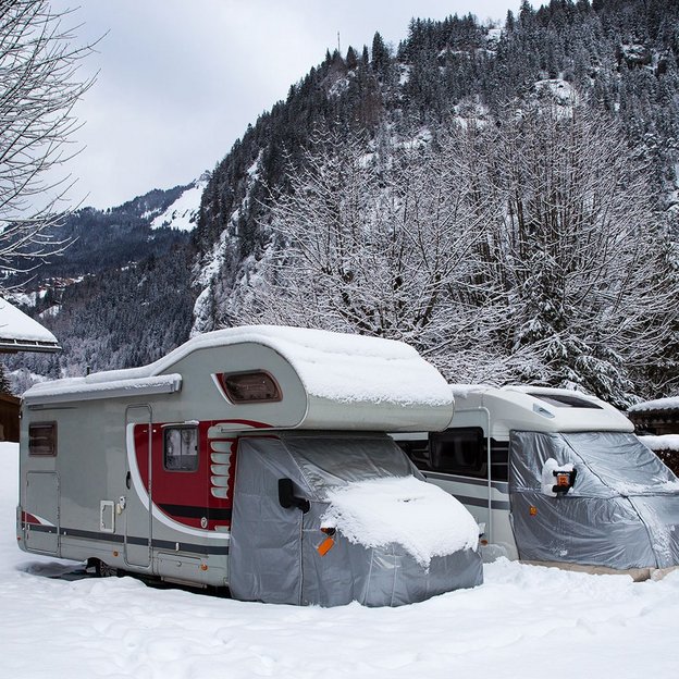 Wohnmobile im Schnee in einer winterlichen Berglandschaft