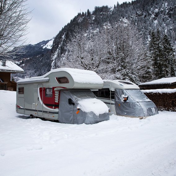 Wohnmobile im Schnee in einer winterlichen Berglandschaft
