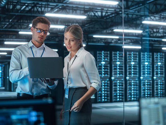 Zwei Personen im Serverraum mit Laptop