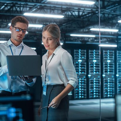 Zwei Personen im Serverraum mit Laptop 