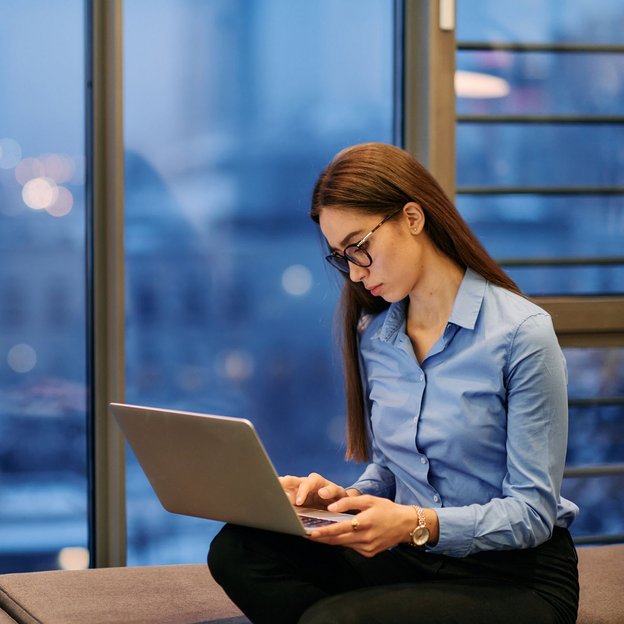 Junge Frau liest konzentriert auf dem Laptop – symbolisiert den digitalen Newsletter für Referent:innen der TÜV NORD Akademie
