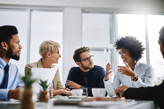 Fünf Personen im Meeting – symbolisiert individuelle Weiterbildungsangebote für Unternehmen durch TÜV NORD Akademie