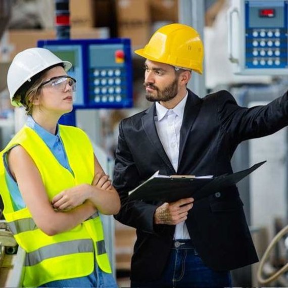 Ingenieurin und Ingenieur in einer industriellen Umgebung