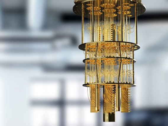 Nahaufnahme eines Quantencomputers mit goldenen zylindrischen Komponenten und komplexer Verkabelung. Die präzise Bauweise zeigt die fortschrittliche Technologie moderner Quantenprozessoren.