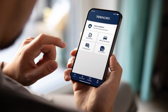 Person nutzt TÜV NORD Fahrschüler-App auf einem Smartphone