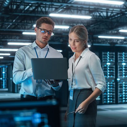 Information Security Officer (TÜV) Zwei Information Security Officer stehen in einem Serverraum und schauen auf ein Tablet.