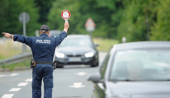 Polizist hält Fahrzeuge auf einer Straße an