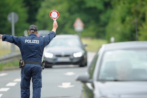 Polizist hält Fahrzeuge auf einer Straße an