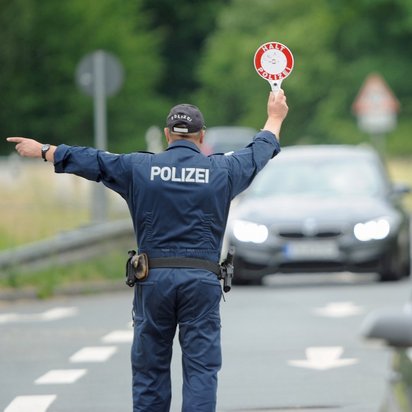 Polizist hält Fahrzeuge auf einer Straße an