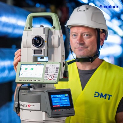 Ein Mitarbeiter mit Schutzhelm und DMT-Warnweste hält ein Vermessungsgerät Pyromat 6000 vor blauen industriellen Rohren.