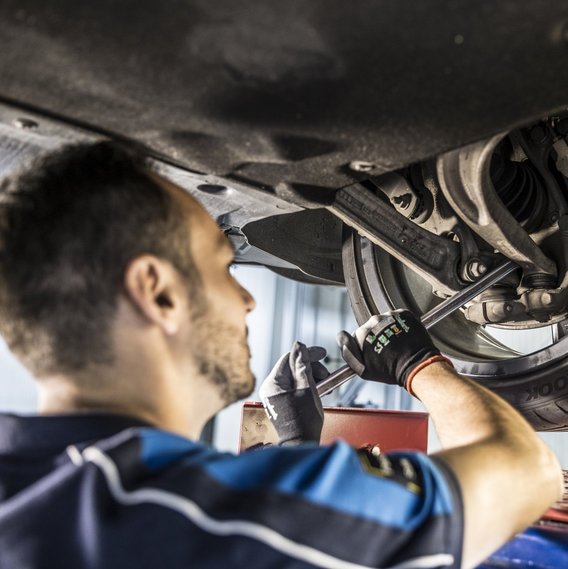 TÜV NORD Prüfer prüft die Reifen eines Autos