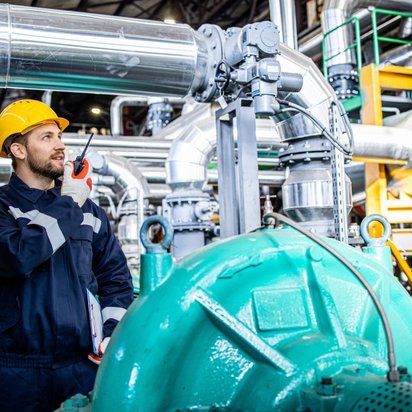 Mitarbeitender prüft eine Maschine