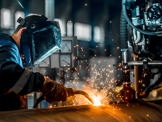 Industrial workers wearing protective equipment while welding - Symbolic image of electricity price compensation