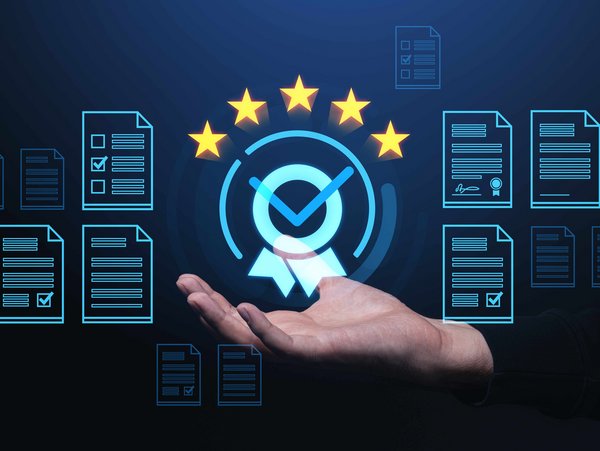 Hand hält digitales Zertifikat mit Häkchen und Sternen, umgeben von Dokumentensymbolen.
