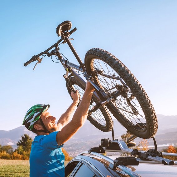 Fahrrad wird auf Autodachträger montiert