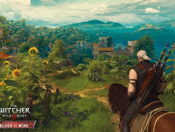 Geralt von Rivia blickt von einem Hügel voller Sonnenblumen auf eine malerische Weinberglandschaft mit mittelalterlichen Türmen und Bergen im Hintergrund - eine Szene aus The Witcher 3: Blood and Wine.
