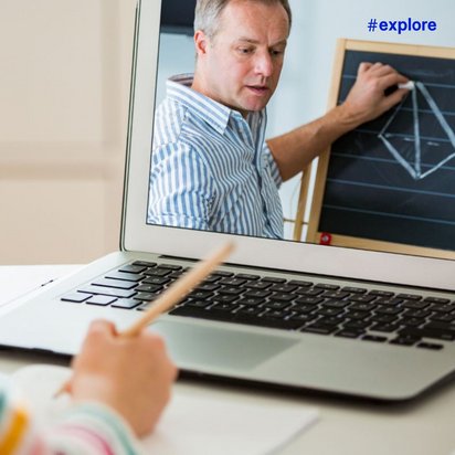 Eine Person mit buntem Streifenshirt nimmt an einer Online-Videokonferenz teil und sieht einen Dozenten im blauen Hemd an einer Tafel mit geometrischen Formen. Die Szene zeigt digitales Lernen oder Remote-Unterricht über einen Laptop in häuslicher Umgebung.