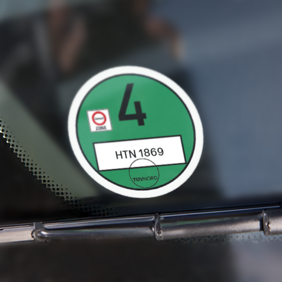 Grüne Umweltplakette auf der Windschutzscheibe eines Fahrzeugs