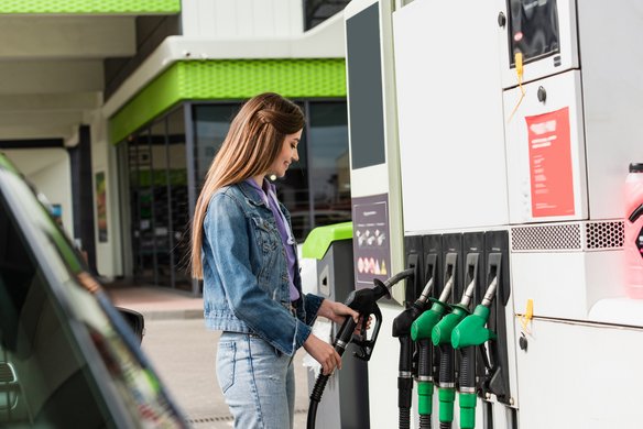 Frau betankt ihr Auto an einer Tankstelle