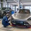 Einzelgenehmigung für Importfahrzeuge – TÜV NORD Prüfung von Scheinwerfern und Fahrzeugtechnik TÜV NORD Prüfer kontrolliert den Scheinwerfer eines importierten Sportwagens im Rahmen der Einzelgenehmigung, im Hintergrund ein Pick-up-Fahrzeug auf dem Prüfstand.