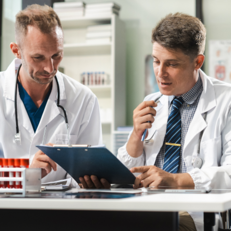 Ein medizinisches Team arbeitet gemeinsam mit einem Tablet und einem Laptop