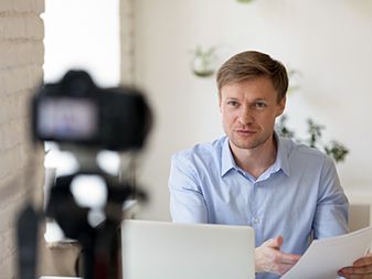 Serious confident young professional lecturer recording educational lecture.