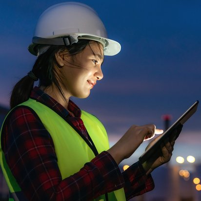 Eine Person in Schutzkleidung steht in einem Industrieviertel