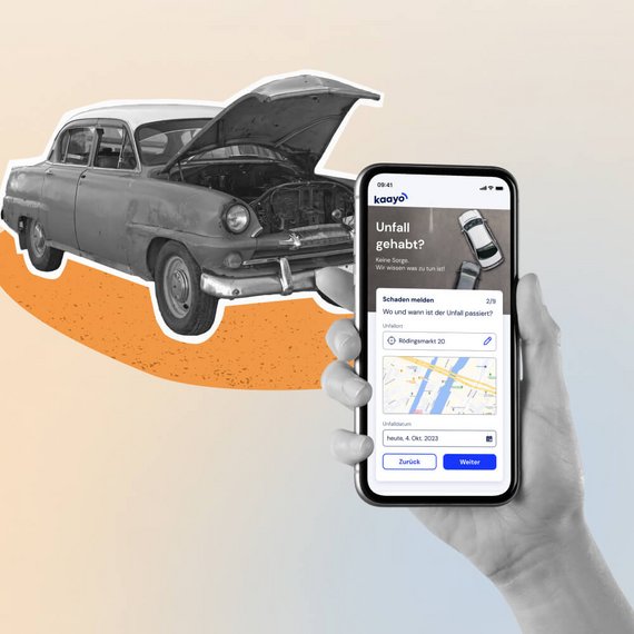 Smartphone mit Unfallmelde-App vor einem Oldtimer