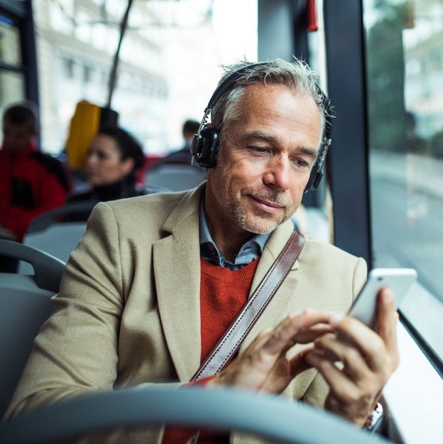 Person nutzt Smartphone in einem öffentlichen Bus
