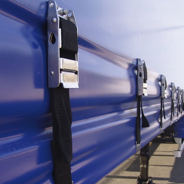 Nahaufnahme der blauen Plane eines LKW-Anhängers mit mehreren Spanngurten und Verschlüssen.