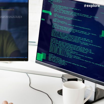 Zwei Computerbildschirmen mit Programmiercode in grüner und weißer Schrift auf dunklem Hintergrund.