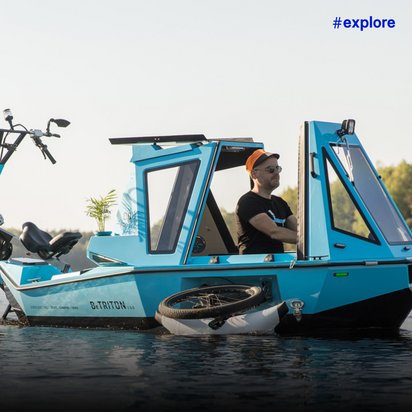 Ein Mann in einem blauen Boot, der es mit einem orangefarbenen Hut und Sonnenbrille auf einem See fährt.