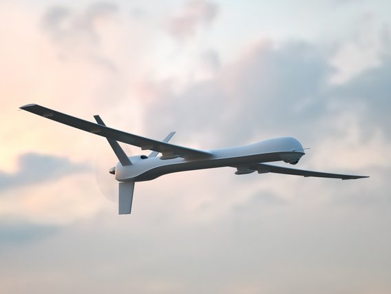 Unbemannte Drohne im Flug vor bewölktem Himmel