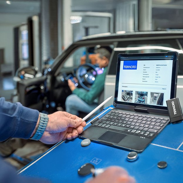 Mitarbeiter bei der Fahrzeugdiagnose mit Laptop an der TÜV NORD Station