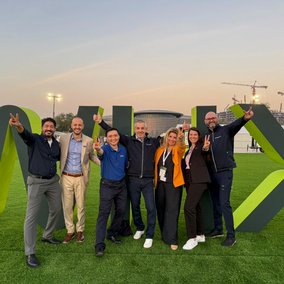 TÜV NORD Team vor dem Eingangsschild der World Health Expo (WHX) in Dubai.