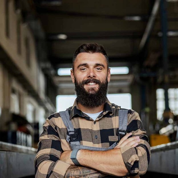 Kfz-Mechatroniker in Arbeitskleidung im Schulungszentrum für Umschulung