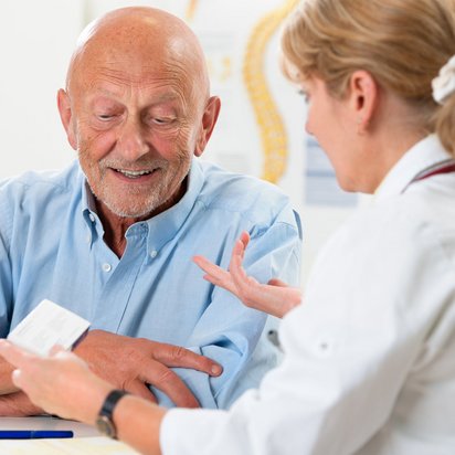Ein älterer Mann wird von einer Ärztin während einer arbeitsmedizinischen Untersuchung beraten.