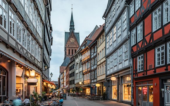Straßenansicht von Hannover mit Fachwerkhäusern und der Stadtkirche im Hintergrund