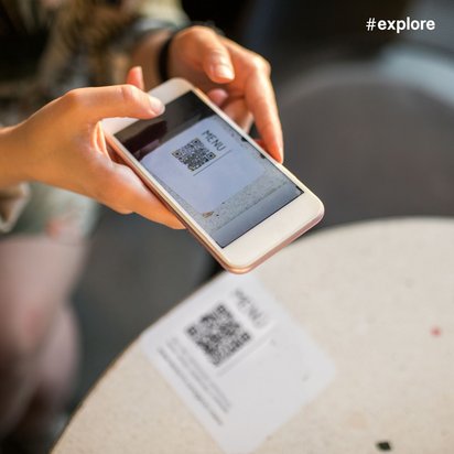 Person geht an Schaufenster vorbei, Plakat mit QR-Code und kyrillischem Text "Wolf Pack" ist sichtbar.